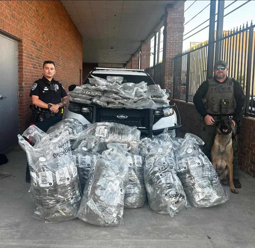 Officers posing with large bags of contraband