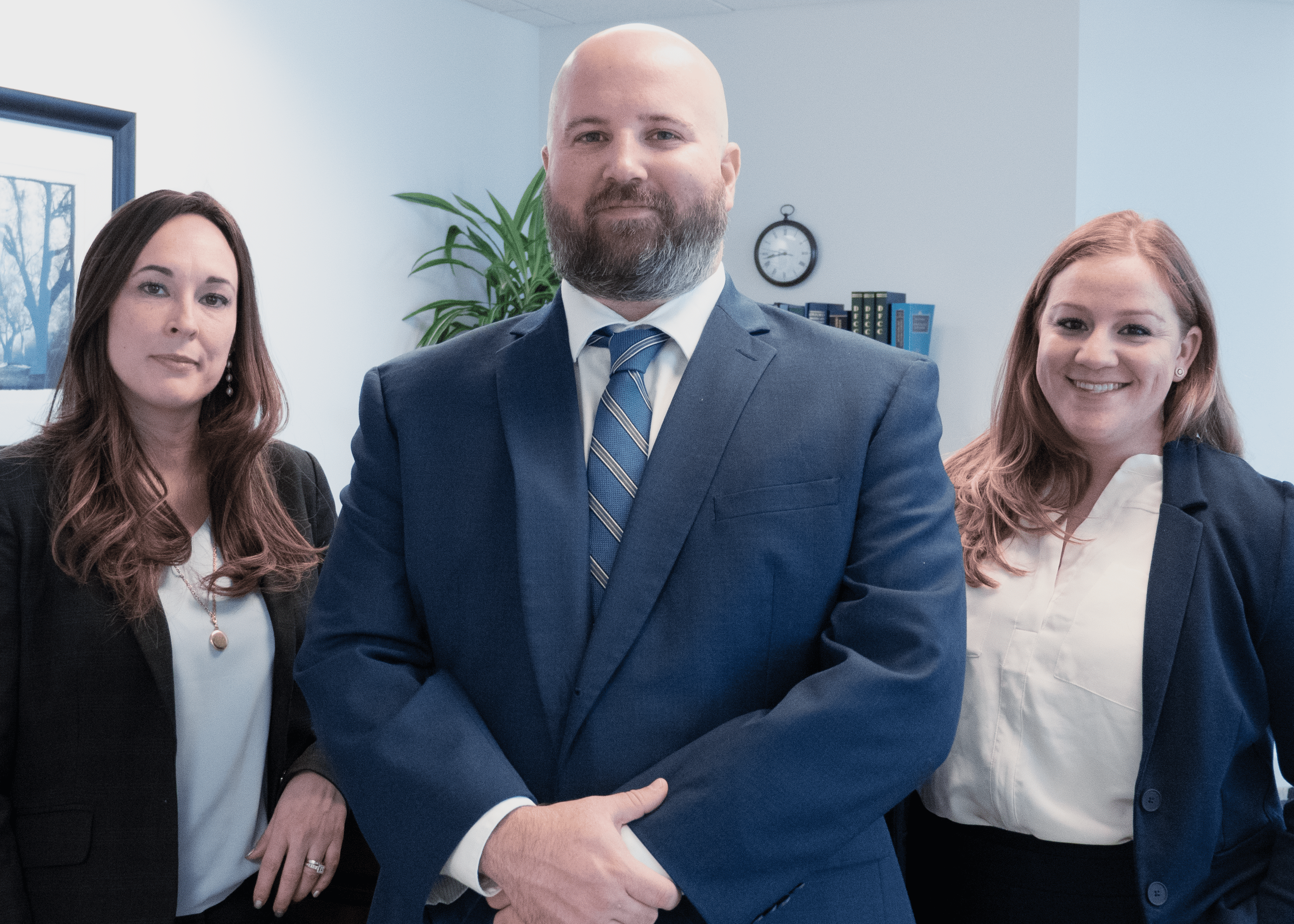 Attorneys Tom Church and Whitney Baker standing with paralegal Emily Brooks